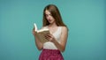 Smart erudite pretty girl in summer dress studying reading large book leafing through encyclopedia