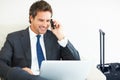 Smart executive using laptop and cellphone. Mature business man working on laptop and talking on mobile phone. Royalty Free Stock Photo