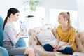 Smart experienced psychologist showing notes to her patient