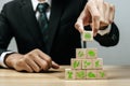 business man investor hand arranging wooden block with agricultural icon on desk