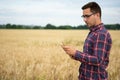 Smart farming using modern technologies in agriculture. Man agronomist farmer with digital tablet computer in wheat field using Royalty Free Stock Photo
