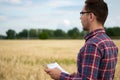 Smart farming using modern technologies in agriculture. Man agronomist farmer with digital tablet computer in wheat field using Royalty Free Stock Photo