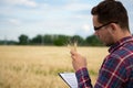 Smart farming using modern technologies in agriculture. Man agronomist farmer with digital tablet computer in wheat field using Royalty Free Stock Photo