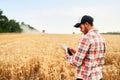 Smart farming using modern technologies in agriculture. Man agronomist farmer holding digital tablet computer standing Royalty Free Stock Photo