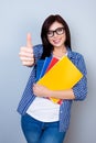 Smart female student in glasses and checkered shirt holding book