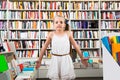 Smart girl child bemused a lot of books in a bookstore