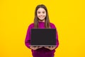 Smart girl with laptop in casual clothes isolated over yellow background. Screen of laptop computer with copyspace