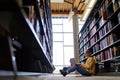 Smart girl student using laptop sitting in university library on floor. Royalty Free Stock Photo