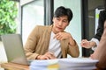 Smart and handsome Asian businessman focused on financial data on laptop screen