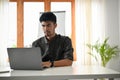 Smart and handsome asian male office worker or tech engineer using laptop computer