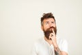 Smart handsome bearded guy having great plan or idea over white background, with copy space. Guy holding his chin and thoughtfully Royalty Free Stock Photo