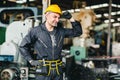 Smart handsome European Russian worker happy working in factory with yellow helmet and safety suit portrait standing at heavy