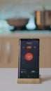 Smart home application on phone placed on kitchen desk in empty house Royalty Free Stock Photo