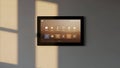 Smart Home Control Panel Touchscreen Mounted on Wall with Soft Window Light Shadow Royalty Free Stock Photo