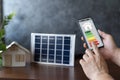 Smart home display and model house with solar panel, energy efficient technology concept. Energy efficiency mobile app on screen