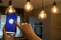 Smart home. Hand controlling smart lamps with app on the phone. Electric concept.