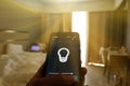 Smart Home: Man Controlling Lights With App On His Phone. electric concept.