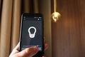 Smart Home: Man Controlling Lights With App On His Phone. electric concept.