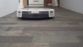 Smart home. Robot vacuum cleaner performs automatic cleaning of the apartment at a certain time. Smart helper at home. A