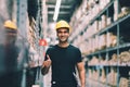 Smart Indian engineer man worker wearing safety helmet doing stocktaking of product management in cardboard box on shelves Royalty Free Stock Photo