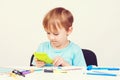 Smart little boy holding calculator. Child doing homework. Back to school concept. School supplies on a white desck Royalty Free Stock Photo