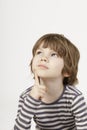 Smart little boy with serious thinking face the white background.