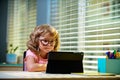 Smart little boy watch online video lesson at home, small child in glasses have web video class on computer, study at Royalty Free Stock Photo