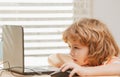 Smart little caucasian boy child sit at table study at laptop notebook, prepare homework at home, kids education concept Royalty Free Stock Photo