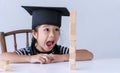 Cute 6s girl success concentrate brick wooden block on table while sitting in the white room. Adorable pigtails Royalty Free Stock Photo