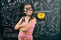 Smart little girl smiling in front of a blackboard Royalty Free Stock Photo