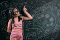 Smart little girl smiling in front of a blackboard Royalty Free Stock Photo