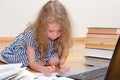 Smart little girl writes diploma. Royalty Free Stock Photo