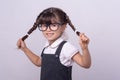 Smart little school child got a bright idea on grey background. Small girl with genius ideas. Royalty Free Stock Photo