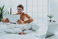 Smart looking male read newspaper in bed