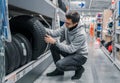 Smart male customer choosing new tires in the supermarket Royalty Free Stock Photo