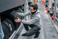 Smart male customer choosing new tires in the supermarket Royalty Free Stock Photo