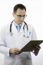 Smart male doctor looking on clipboard with patient`s diagnosis. Close up