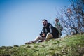 Smart man backpack sitting on the grass hill. Royalty Free Stock Photo