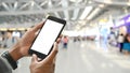 Smart man`s hands holding a cropped black smartphone with white blank screen.