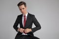 Smart man in suit buttoning his lounge jacket while sitting Royalty Free Stock Photo