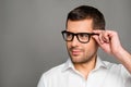 Smart man touching his glasses and looking ahead Royalty Free Stock Photo
