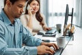 Smart manager typing on laptop while woman coworker calling on phone. Postulate. Royalty Free Stock Photo