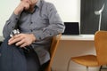 smart medical doctor holding stethoscope and thinking with laptop computer on dark wooden desk in modern office Royalty Free Stock Photo