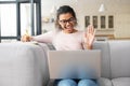 Smart mixed-race teenage girl waving at laptop