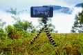 Smart Mobile phone holding on mini Tripod stand at beautiful landscape. Mobile tripod Stock images