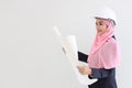 Smart muslim young asian woman wearing blue suit smiling confident holding blueprint in studio. Isolated white background portrait