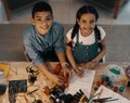 Smart is the new cool guys. High angle portrait of two adorable young siblings building a robotic toy together at home. Royalty Free Stock Photo