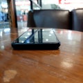 Smart phone black above brown table