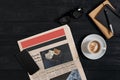 Smart phone with black display on wooden background. Newspaper and coffee on wooden table. Top view. Royalty Free Stock Photo