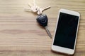 Smart phone with blank screen and car remote alarm control key on the table Royalty Free Stock Photo